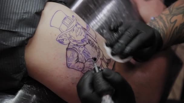 Profesionální tetování umělec dělá tetování na mužské ruce.
