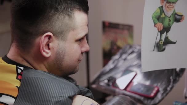 Artista profesional del tatuaje hace un tatuaje en el brazo de un hombre . — Vídeos de Stock