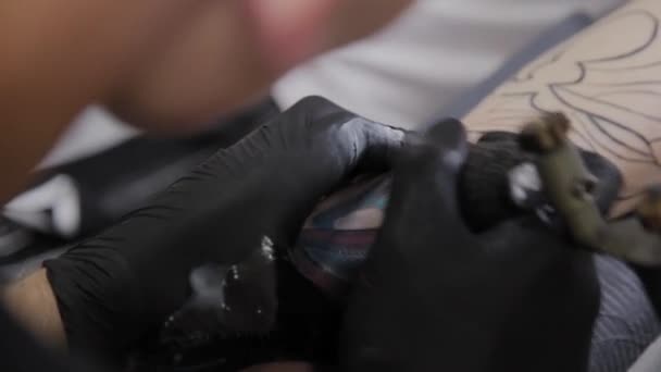 Professionele tattoo artiest maakt een tatoeage op de arm van een man. — Stockvideo