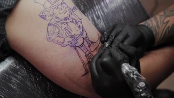 Professionele tattoo artiest maakt een tatoeage op de arm van een man. — Stockvideo