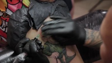 Profesyonel dövme sanatçısı bir adamın kolunda dövme yapar..