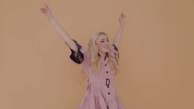 Mutlu genç kız sarı arka planda eğleniyor.