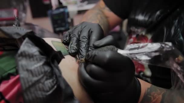 Artista profesional del tatuaje hace un tatuaje en el brazo de un hombre . — Vídeos de Stock