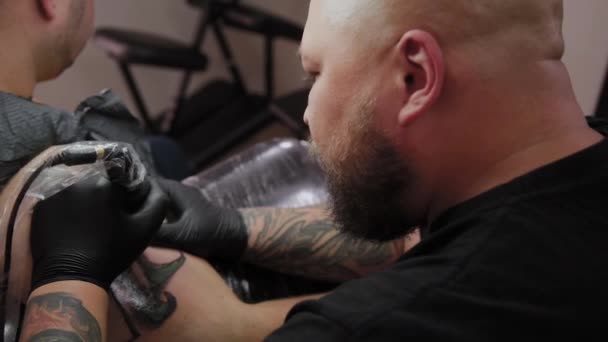 Artista profesional del tatuaje hace un tatuaje en el brazo de un hombre . — Vídeo de stock