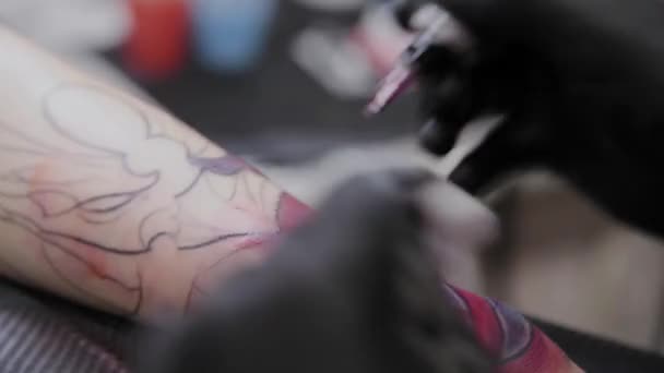 Professionele tattoo artiest maakt een tatoeage op de arm van een man. — Stockvideo