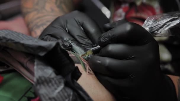 Artista profesional del tatuaje hace un tatuaje en el brazo de un hombre . — Vídeo de stock