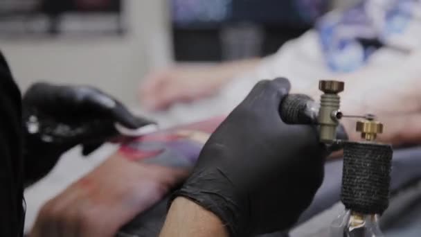 Professioneller Tätowierer lässt sich den Arm eines Mannes tätowieren. — Stockvideo