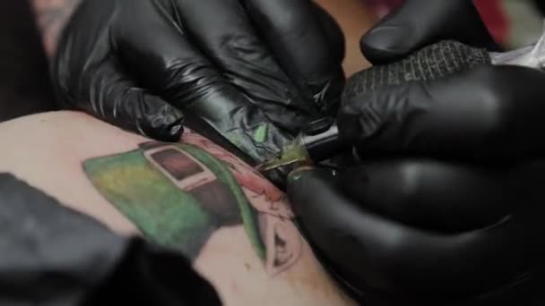 Il tatuatore professionista fa un tatuaggio sul braccio di un uomo . — Video Stock
