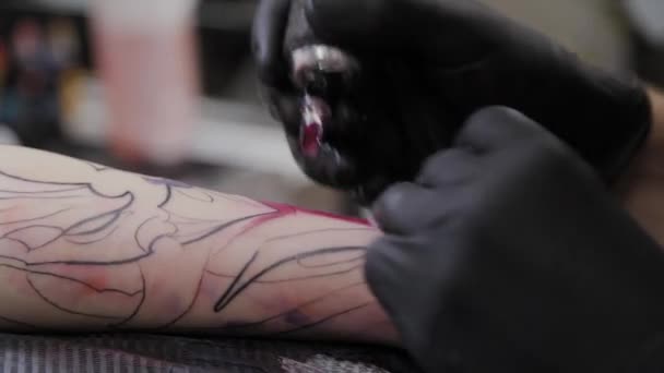 Il tatuatore professionista fa un tatuaggio sul braccio di un uomo . — Video Stock