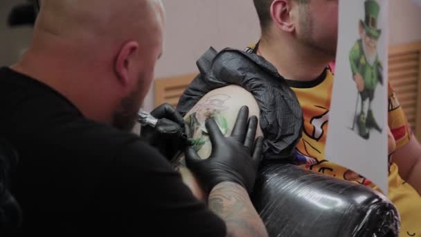 Professioneller Tätowierer lässt sich den Arm eines Mannes tätowieren. — Stockvideo