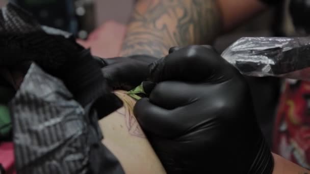 Professionell tatuerare gör en tatuering på en mans arm. — Stockvideo