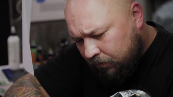 Professionele tattoo artiest maakt een tatoeage op de arm van een man. — Stockvideo