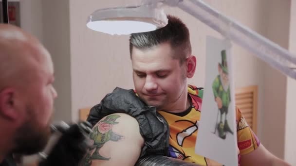 Tatoueur professionnel fait un tatouage sur le bras d'un homme . — Video