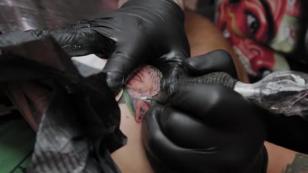 Professional tattoo artist makes a tattoo on a man s arm. — Stock Video