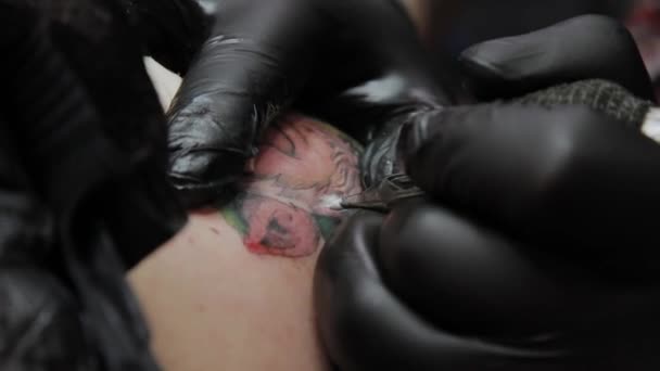 Professionell tatuerare gör en tatuering på en mans arm. — Stockvideo