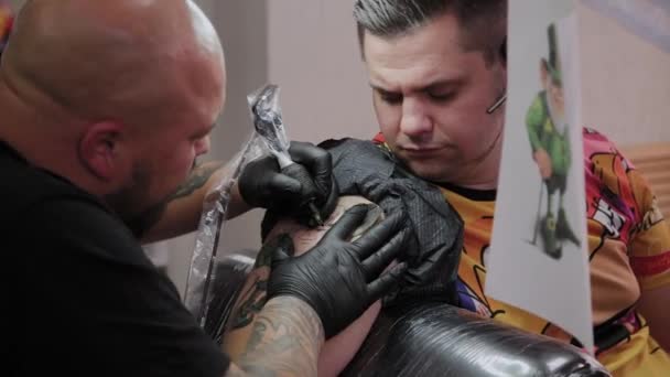 Artista profesional del tatuaje hace un tatuaje en el brazo de un hombre . — Vídeos de Stock