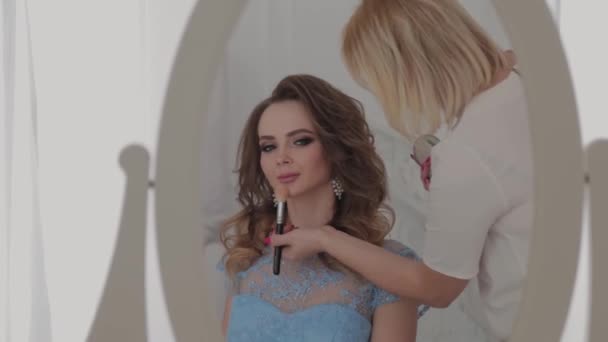 Schöne junge Mädchen macht Make-up-Artist. — Stockvideo