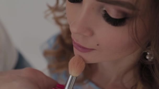 Mooi jong meisje maakt make-up kunstenaar. — Stockvideo