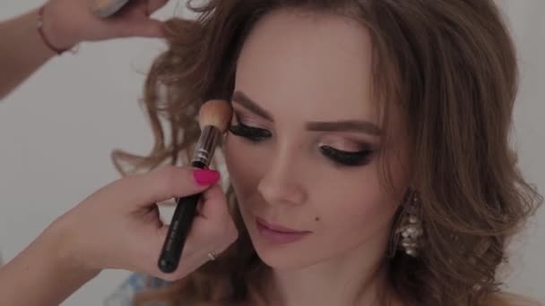 Vacker ung flicka gör makeup artist. — Stockvideo