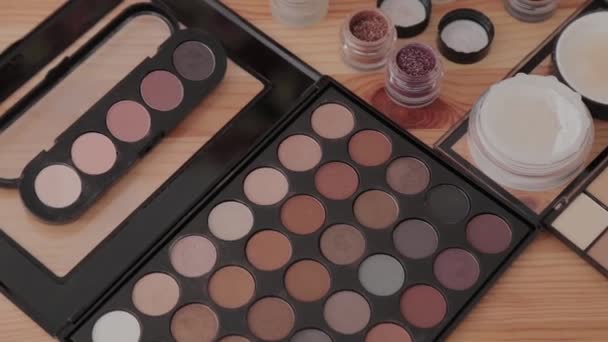 Kit de maquillaje profesional en un estudio de maquillaje sobre una mesa de madera . — Vídeos de Stock