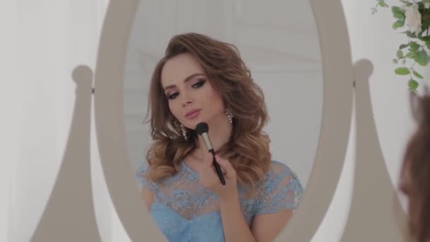 Krásná mladá dívka dělá sama make-up. — Stock video