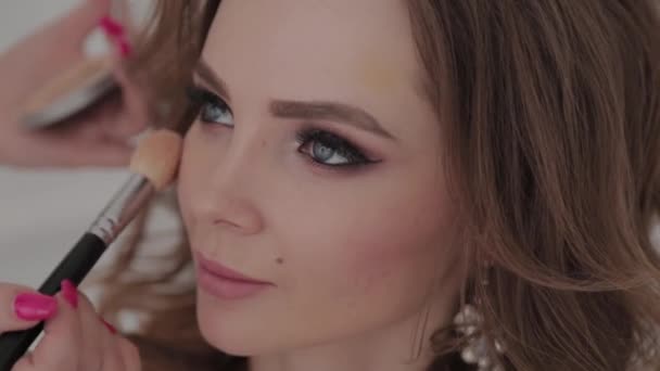 Schöne junge Mädchen macht Make-up-Artist. — Stockvideo