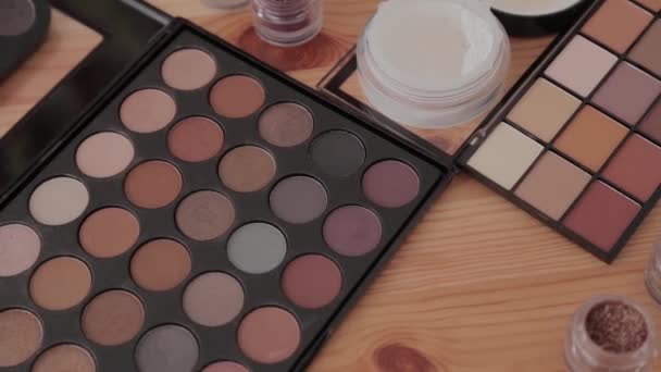 Kit de maquillaje profesional en un estudio de maquillaje sobre una mesa de madera . — Vídeo de stock