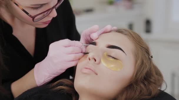 Επαγγελματική makeup artist μαδώντας φρύδια για τον πελάτη στο σαλόνι ομορφιάς. — Αρχείο Βίντεο