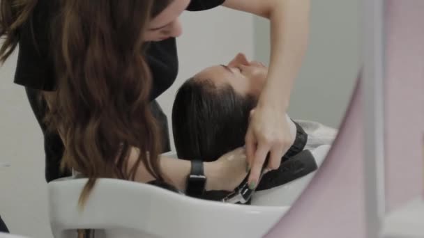 Bella ragazza lavarsi i capelli al parrucchiere . — Video Stock