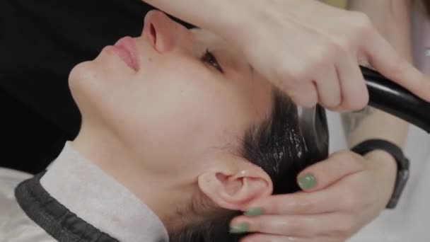 Beautiful young girl wash their hair at the hairdresser. — Stock Video