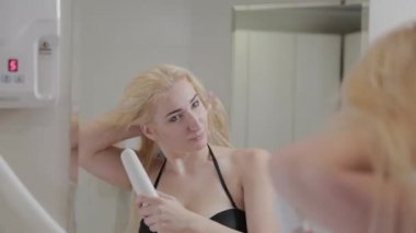 Güzel genç bir kız, kaplıca tedavisinden sonra saç kurutma makinesiyle saç kurutuyor..