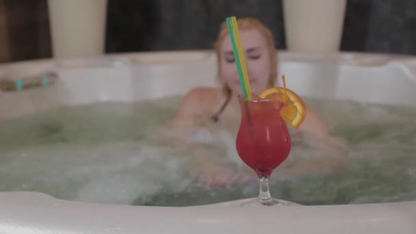 Beautiful girl with a cocktail in a jacuzzi. — Stock Video
