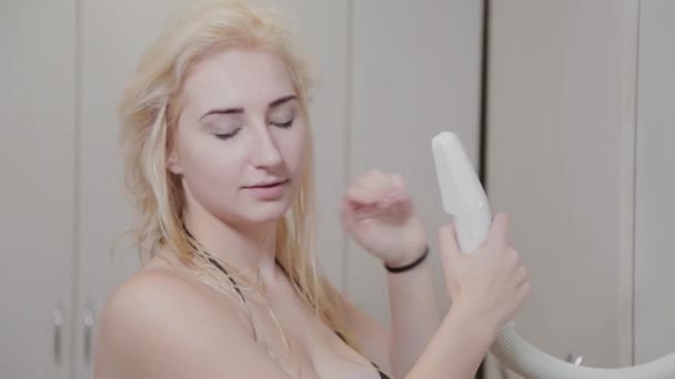 Bella ragazza asciuga i capelli con un asciugacapelli dopo i trattamenti termali . — Video Stock