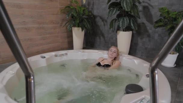 Bella ragazza si rilassa in una vasca idromassaggio . — Video Stock
