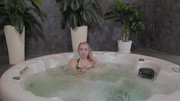 Schönes junges Mädchen entspannt sich im Whirlpool. — Stockvideo