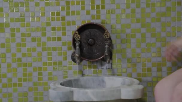 En vacker flicka häller vatten i en hamam. Spabehandlingar. — Stockvideo