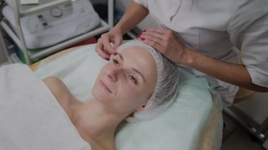 Profesyonel güzellik uzmanı hastaların koruyucu başlıklarını ayarlıyor..