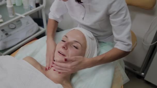 Cosmetologist profissional aplica hidratante para rosto de menina . — Vídeo de Stock