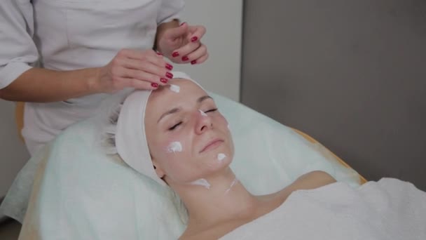 Cosmetólogo profesional haciendo masaje facial en el salón de belleza . — Vídeos de Stock