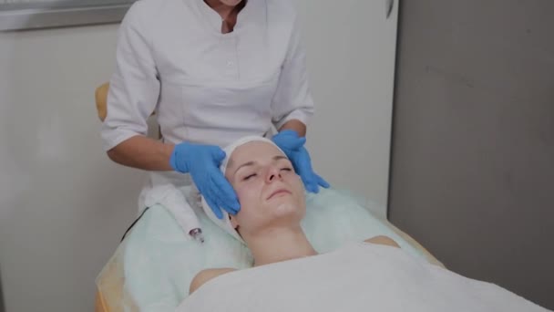 Profesjonalny kosmetolog robi masaż twarzy w salonie piękności. — Wideo stockowe