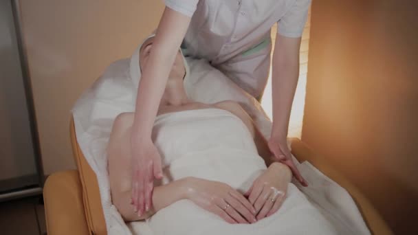 Esteticista profissional faz uma massagem complexa para uma jovem no escritório de cosmetologia . — Vídeo de Stock