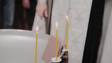 Ortodoks Kilisesinde mum yakan bebeklerin vaftiz yazı tipleri..