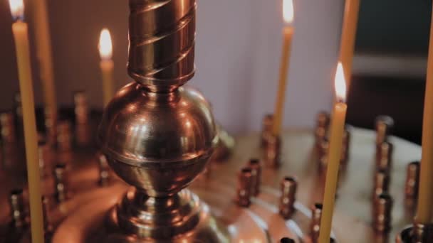 Brinnande kyrkljus på en ljusstake under gudstjänsten. — Stockvideo