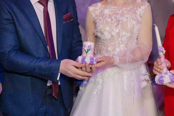 Bougie dans les mains des jeunes mariés symbolise le foyer et le bien-être de la famille . — Photo