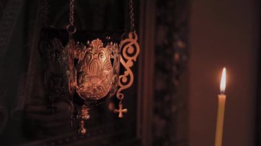 Kilise ayini sırasında şamdanla kilise mumlarını yakmak..