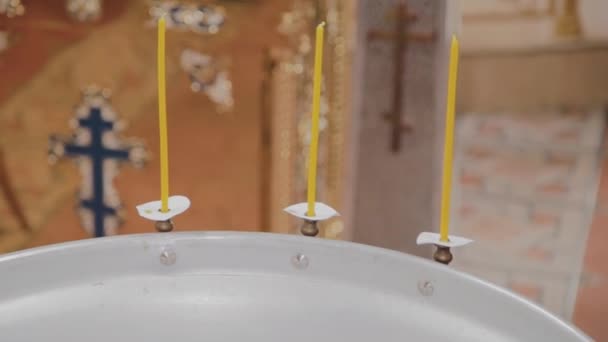 Fuentes para el bautismo de bebés con velas encendidas en la Iglesia Ortodoxa . — Vídeos de Stock