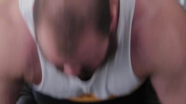 Büyük ve güçlü bir halterci halteri kaldırır ve çok gergindir..