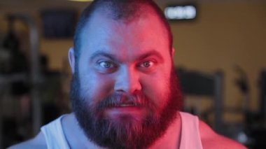 Neon ışığı altında kötü sakallı bir adamın kocaman yüzü..