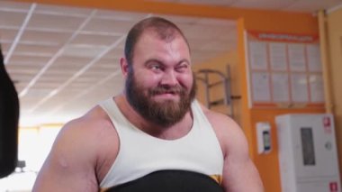 Çok büyük sakallı vücut geliştirici spor salonunda bacak çalıştırıyor..