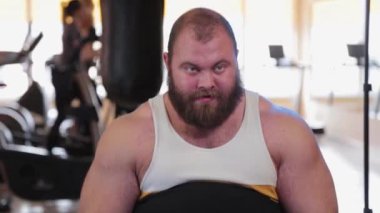 Çok büyük sakallı vücut geliştirici spor salonunda bacak çalıştırıyor..